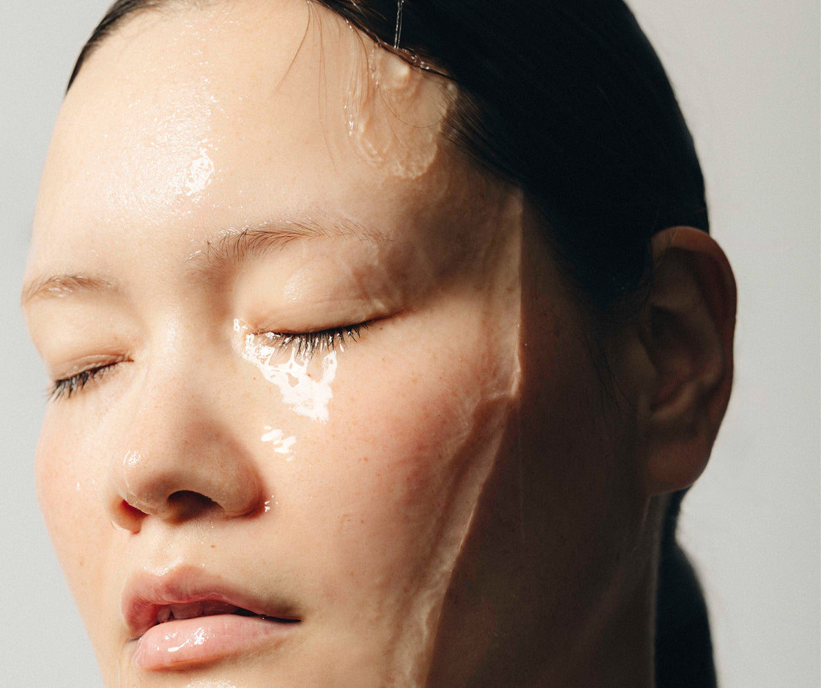 Nahaufnahme eines Frauengesichts, Augen geschlossen, Wasser fließt darüber