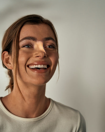 fröhliches Porträt einer Frau nach Behandlung gegen die Nasenfältchen durch Lvate